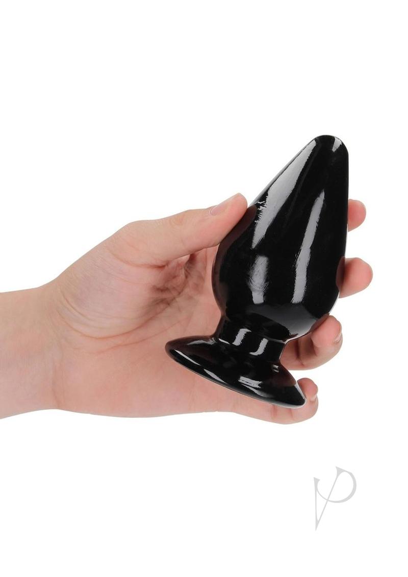 Hand holding RealRock Crystal Clear 4.5 Inch Anal Plug Black, showcasing its tapered tip and flared base.