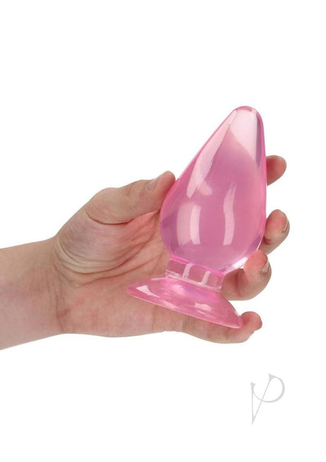 Hand holding RealRock Crystal Clear Anal Plug 4.5 Inch Pink showcasing its sleek design.