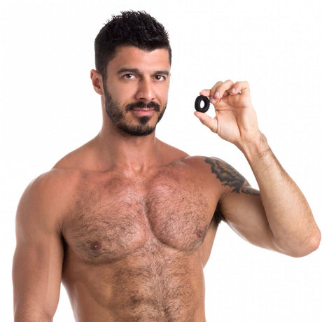 A man holding the Sport Fucker Traction Ring Silicone Cock Ring, showcasing its design and quality.