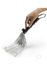 Fifty Shades of Grey Please Sir Flogger Black Silver being held, showcasing its faux leather and metallic design.