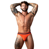 Male Power Soo Cumfy Thong Orange Small Medium on a muscular man with tattoos, showcasing comfort and style.