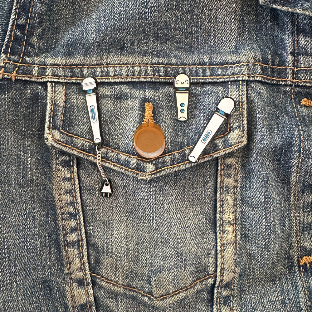 Wood Rocket Magic Wand Rechargeable Enamel Pin displayed on a denim jacket pocket.