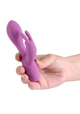X and O's Devotion Silicone Rabbit Vibrator Purple held in a hand for targeted pleasure and intimate moments.