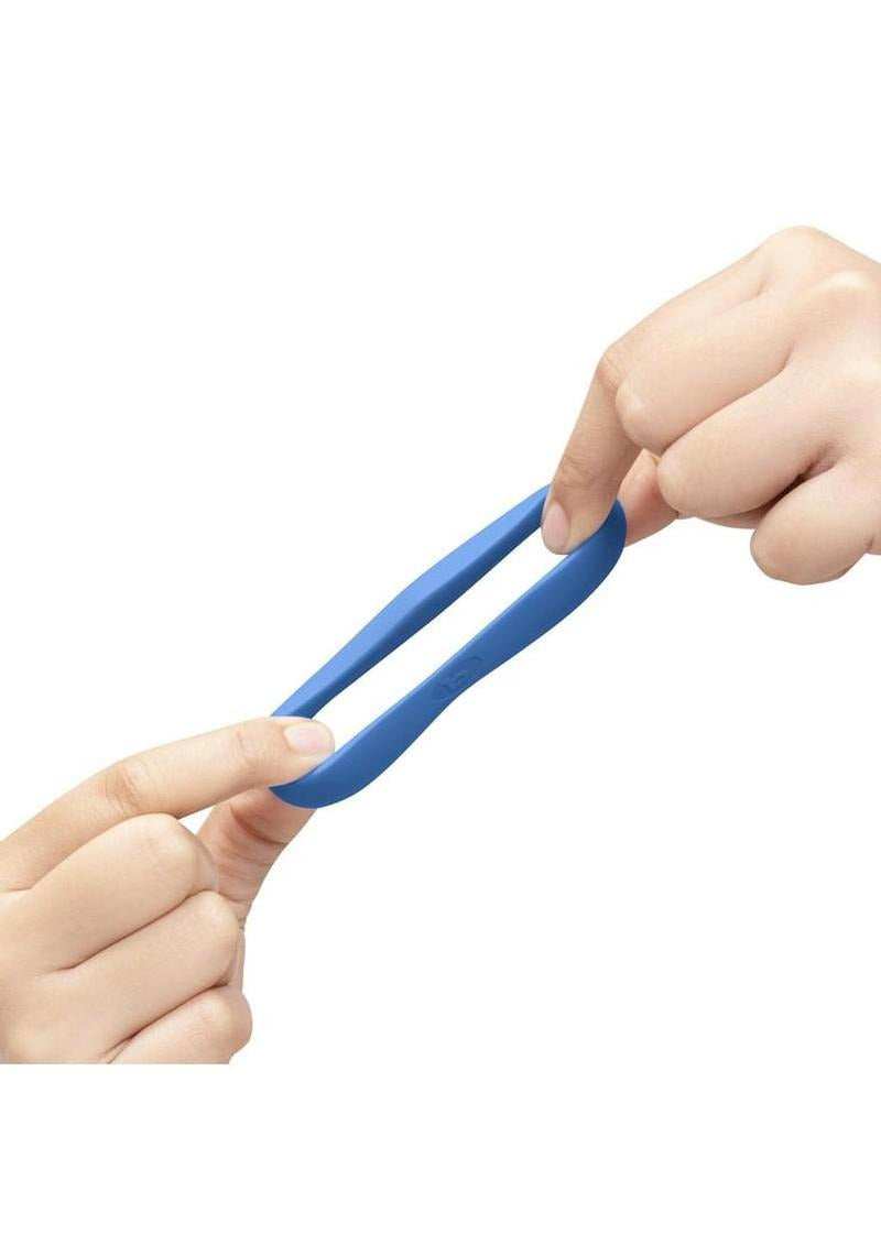 B-Vibe Flex Ring Delta Silicone Cock Ring Blue being stretched by hands, showcasing its flexibility and comfort.