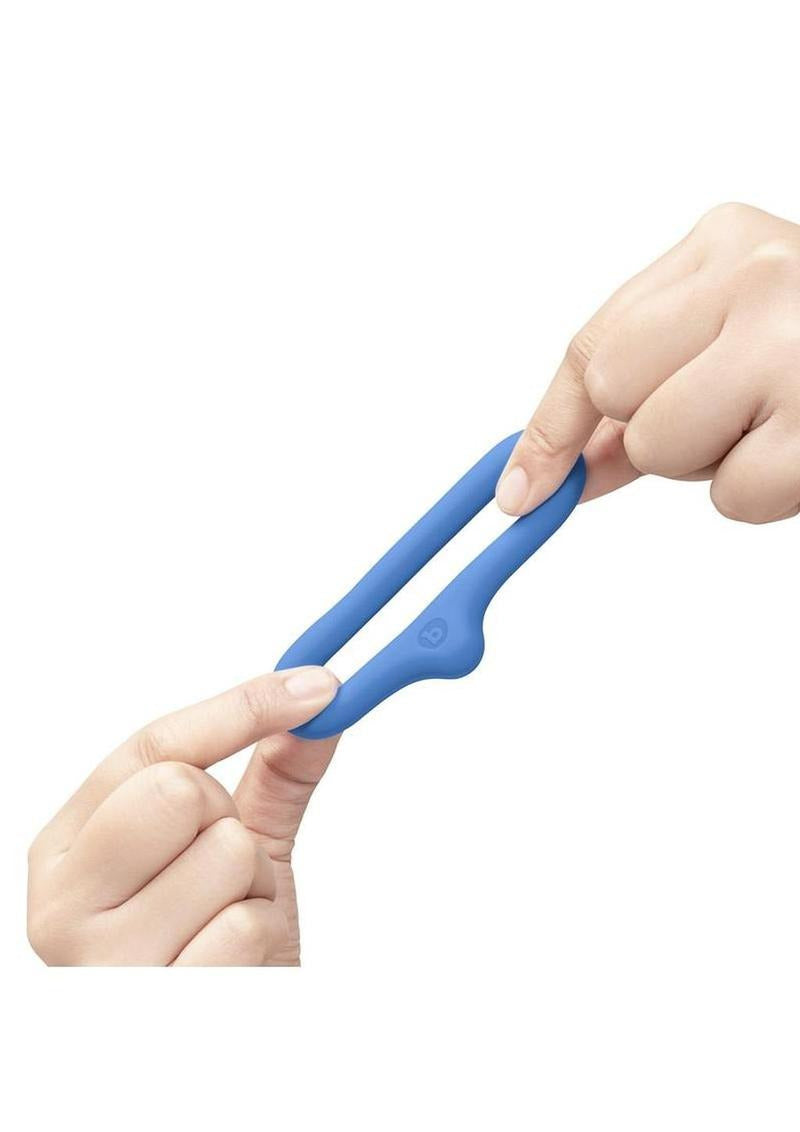 B-Vibe Flex Ring Drip Silicone Cock Ring Blue held between two fingers, showcasing its design and flexibility.