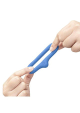 B-Vibe Flex Ring Drip Silicone Cock Ring Blue held between two fingers, showcasing its design and flexibility.