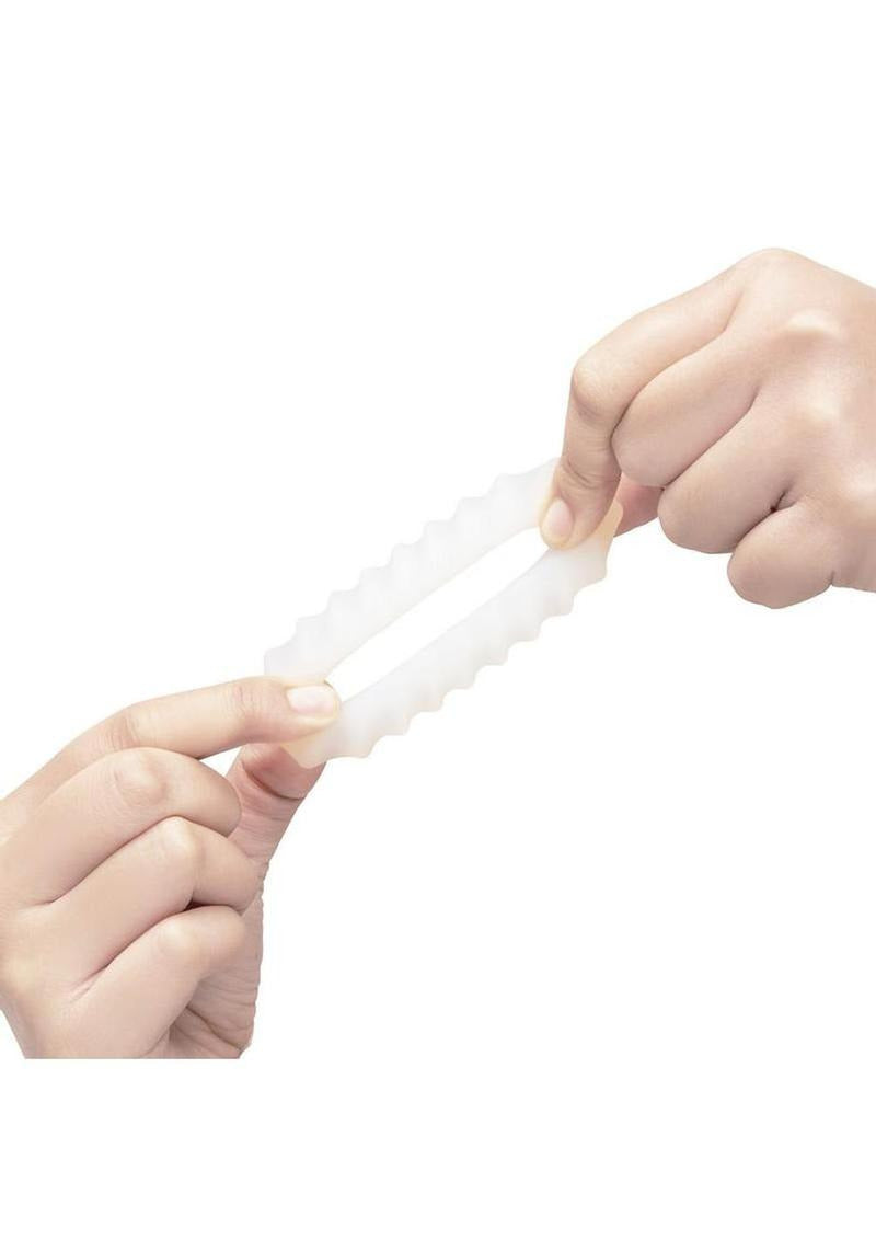 Person holding B-Vibe Flex Ring Ripple Silicone Cock Ring White, showcasing its flexible and smooth design.