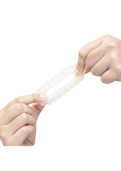 Person holding B-Vibe Flex Ring Ripple Silicone Cock Ring White, showcasing its flexible and smooth design.