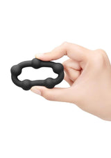 B-Vibe Snug Ring Orbit Nubby Silicone Cock Ring Black held in hand showcasing its design and comfort.