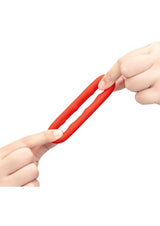 B-Vibe Flex Ring Grip Silicone Cock Ring Red being stretched between two hands, showcasing its flexibility and durability.