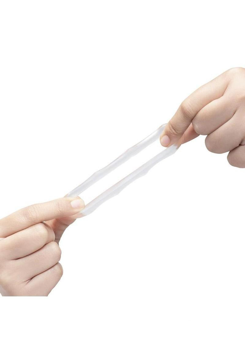 B-Vibe Stretch Tech Bolt Ultra Stretchy Cock Ring Clear being stretched between hands, showcasing its flexibility.