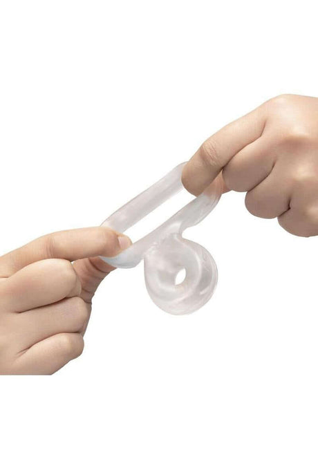 B-Vibe Stretch Tech Double Barrel Ultra Stretchy Cock Ring Clear being stretched between two hands.