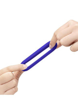 B-Vibe Flex Ring GT Silicone Cock Ring 32 mm Blue being stretched between two hands.