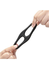 B-Vibe Flex Ring Eight Silicone Cock Ring Black held between two fingers, showcasing its flexible design.