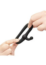 B-Vibe Flex Ring Tap Silicone Cock Ring Black being held in hands demonstrating its flexible design.