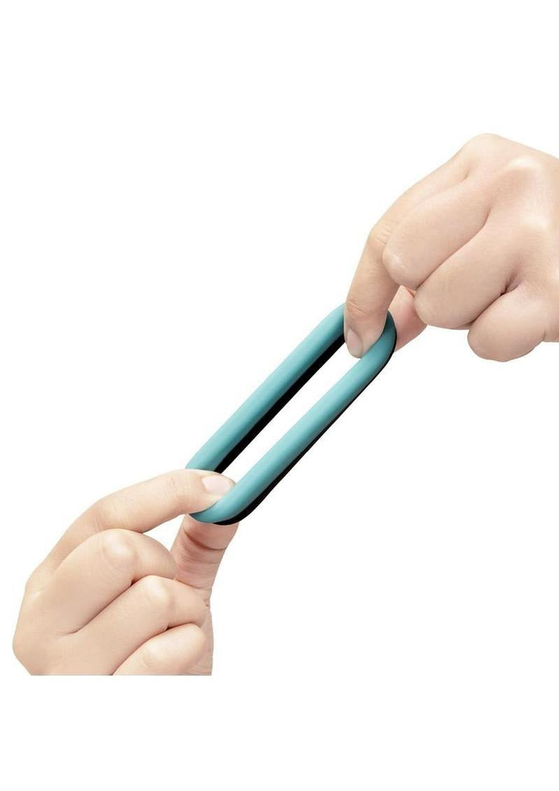 B-Vibe Flex Band Silicone Cock Ring 30 mm Blue being stretched by hands to showcase flexibility and comfort.