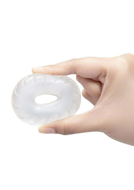 B-Vibe Stretch Tech Drive Ultra Stretchy Cock Ring Clear held in hand, showcasing its transparent design.