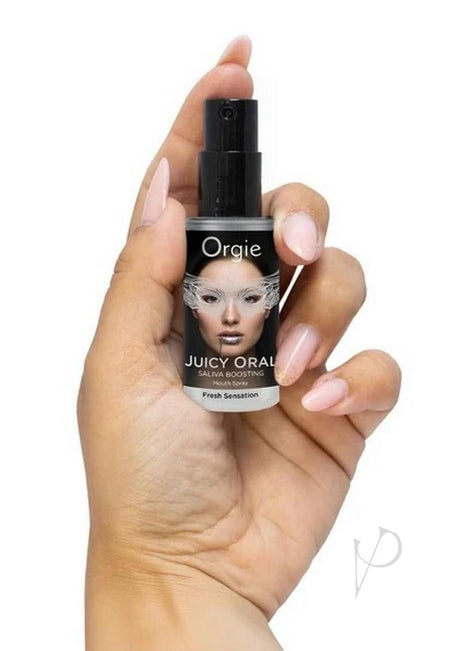 Orgie Juicy Oral Refreshing Mouth Spray 0.5 Oz Mint held in hand, featuring mint flavor for intimate moments.