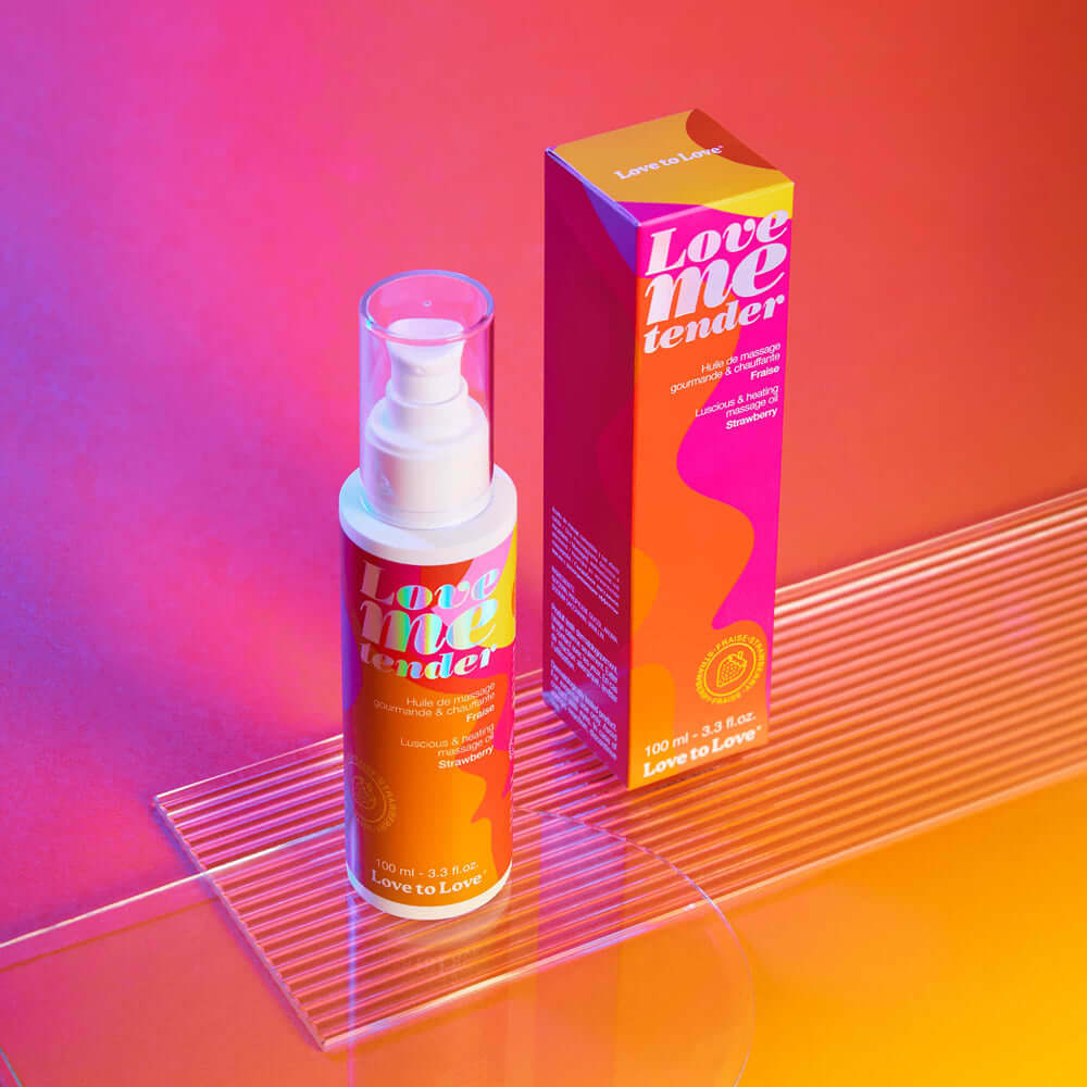 Love Me Tender Luscious & Heating Massage Oil Strawberry 3.3 Oz in a vibrant packaging, designed for intimate moments.