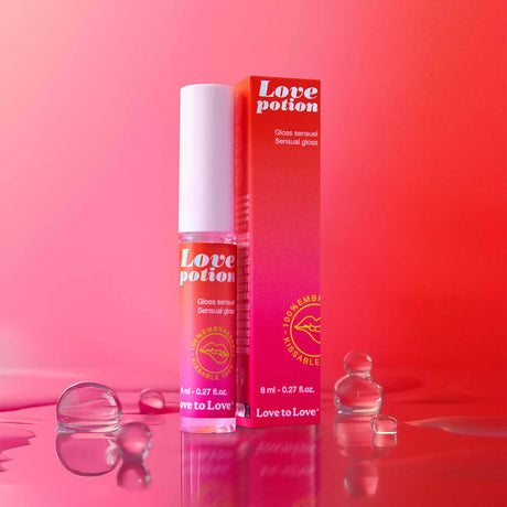 Love to Love Love Potion Sensual Gloss 0.27 Oz in a vibrant setting with bubbles and packaging.