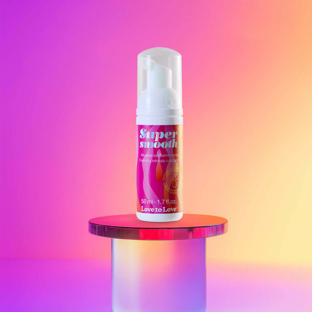 Love to Love Super Smooth Foaming Intimate Lubricant 1.7 Oz bottle on a colorful background