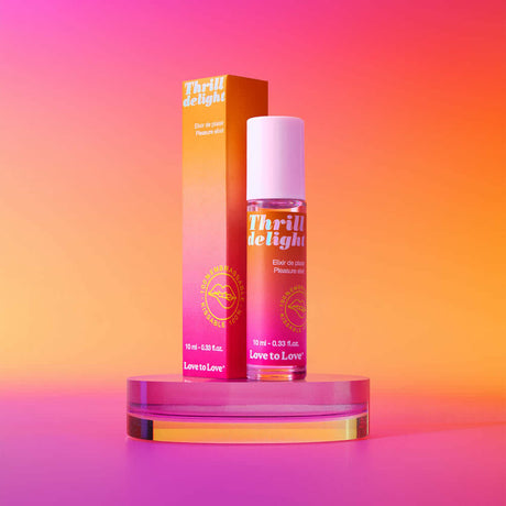 Love to Love Thrill Delight Pleasure Elixir 0.33 Oz with vibrant packaging on a colorful background.
