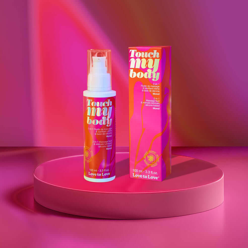 Touch My Body 2-in-1 Massage Fluid & Intimate Lubricant Monoi 3.3 Oz bottle and box on a colorful background.