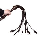 Prowler RED Leather Flogger Brown held in hand, showcasing its durable leather and flexible tails for BDSM play.