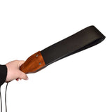 Prowler RED Leather & Wood Flapper Paddle held in hand showcasing its sleek design and sturdy wooden handle.