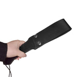 Person holding the Prowler RED Leather Paddle Black S with a sleek black finish.