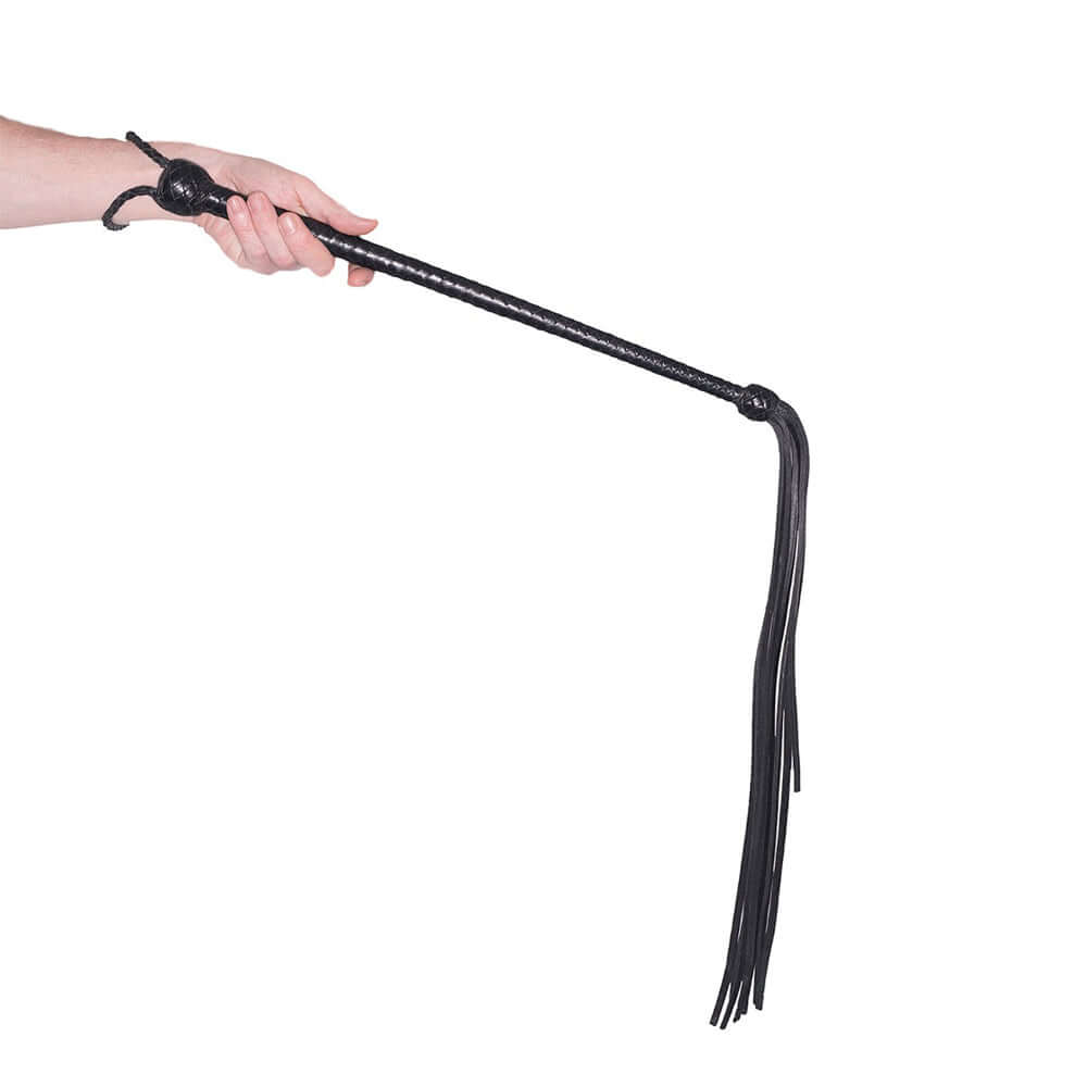 Prowler RED Long Handled Whip Black held in a hand, showcasing its long handle and flexible whip tail.