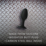 Prowler RED Weighted Butt Plug Black Small on a textured metallic background, highlighting its silicone material and weighted design.