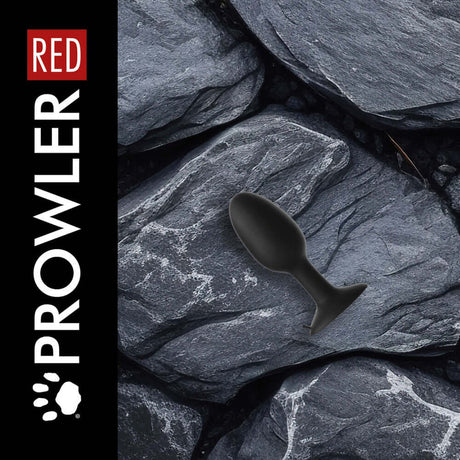 Prowler RED Weighted Butt Plug Black Medium on textured rocks background.