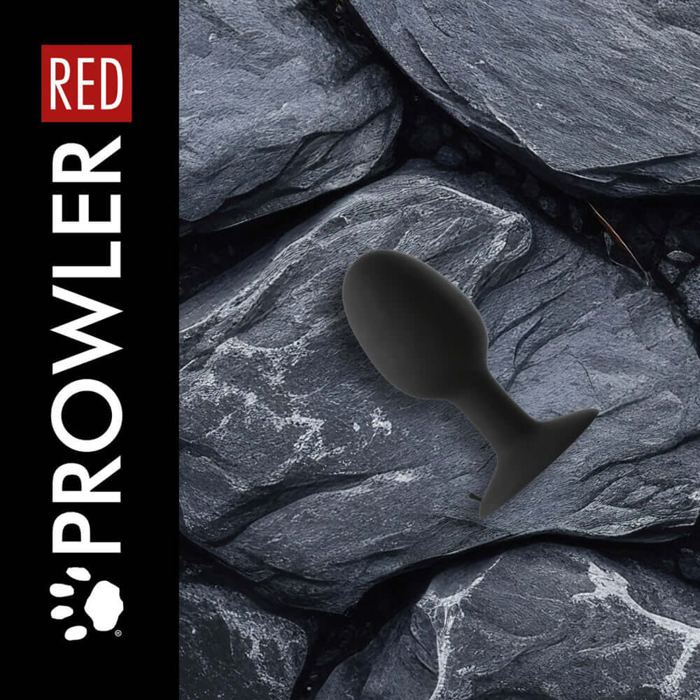 Prowler RED Weighted Butt Plug Black Large on textured stone background, highlighting its smooth tapered design.
