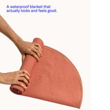 Dame Thro Waterproof Sex Blanket Copper being rolled up, showcasing its stylish design and functional comfort.