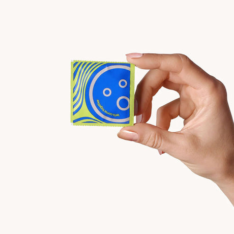 Dame Ultra Thin Condoms 12-Pack held in hand, featuring colorful packaging design for reliable protection and natural feel.