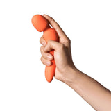 Dame Min Mini Wand Vibrator Papaya being held, showcasing its compact design and vibrant color.