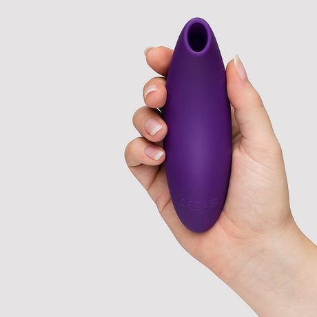 We-Vibe Melt 2 Pleasure Air Clitoral Stimulator Purple held in hand, showcasing its ergonomic design.