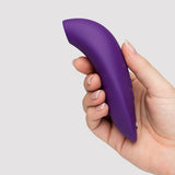 We-Vibe Melt 2 Pleasure Air Clitoral Stimulator Purple held in a woman's hand, showcasing ergonomic design for intimacy.