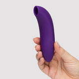 We-Vibe Melt 2 Pleasure Air Clitoral Stimulator Purple held in hand, showing its sleek ergonomic design.