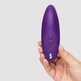 We-Vibe Melt 2 Pleasure Air Clitoral Stimulator Purple held in hand with buttons visible.