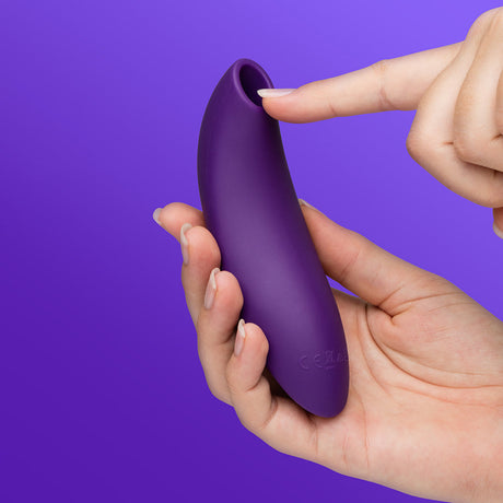 We-Vibe Melt 2 Pleasure Air Clitoral Stimulator Purple held in hand, showcasing its ergonomic design.