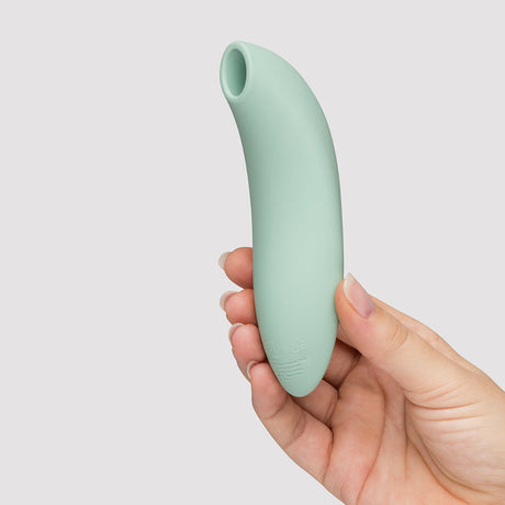 We-Vibe Melt 2 Pleasure Air Clitoral Stimulator Sage held in hand, featuring a sleek design and soft silicone.