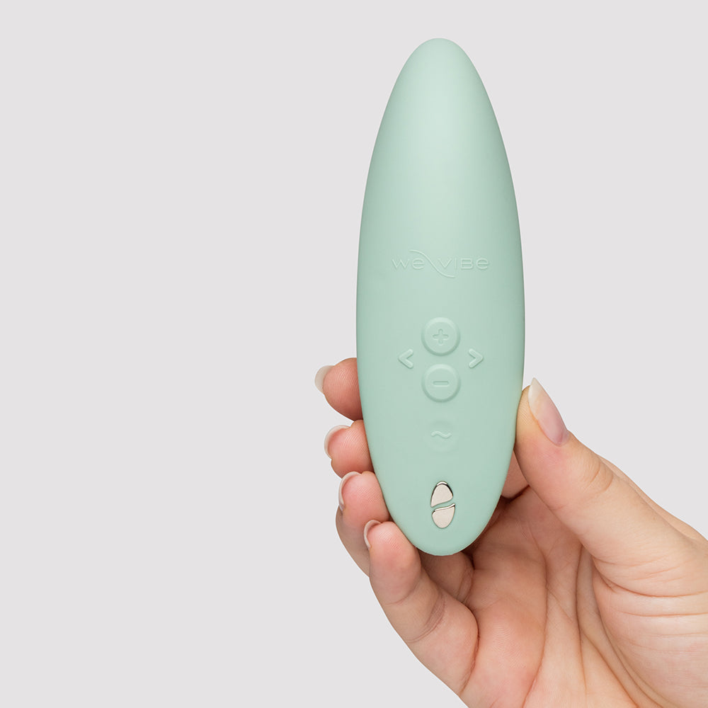We-Vibe Melt 2 Pleasure Air Clitoral Stimulator Sage held in hand, showcasing its sleek design and buttons.