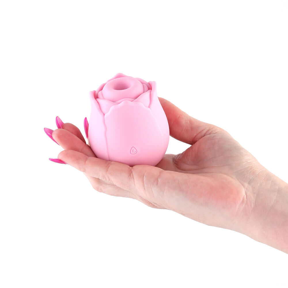 INYA The Vibrating Rose Pink held in a hand, showcasing its elegant rose design and smooth silicone texture.