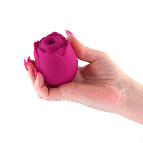 A hand holding INYA The Vibrating Rose Red, a rose-shaped pleasure device designed for targeted stimulation.