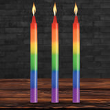 Master Series Pride Candles Rainbow Drip Candle Set of 3 with vibrant rainbow colors and flames on a wooden table.
