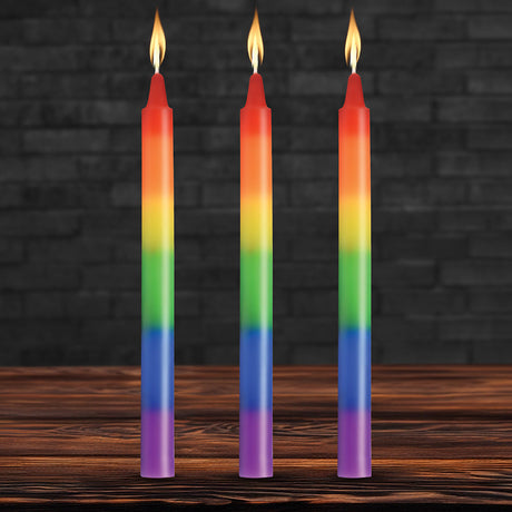 Master Series Pride Candles Rainbow Drip Candle Set of 3 with vibrant rainbow colors and flames on a wooden table.