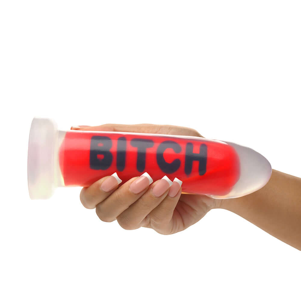 Master Series BITCH Silicone Dildo held in hand, showcasing bold design and intense sensuality.