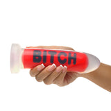 Master Series BITCH Silicone Dildo held in hand, showcasing bold design and intense sensuality.